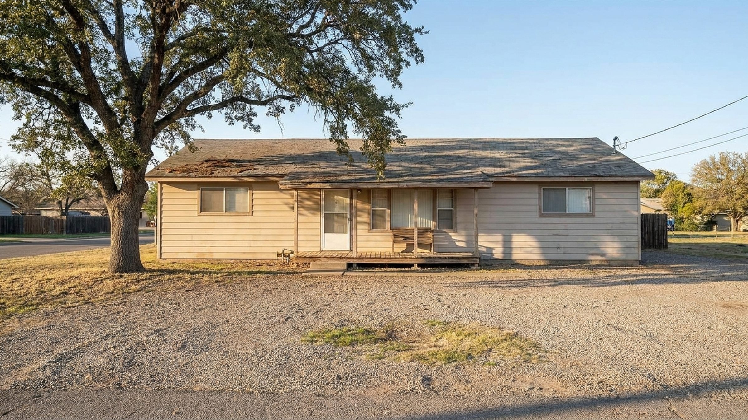 Single-story house beneath a large tree